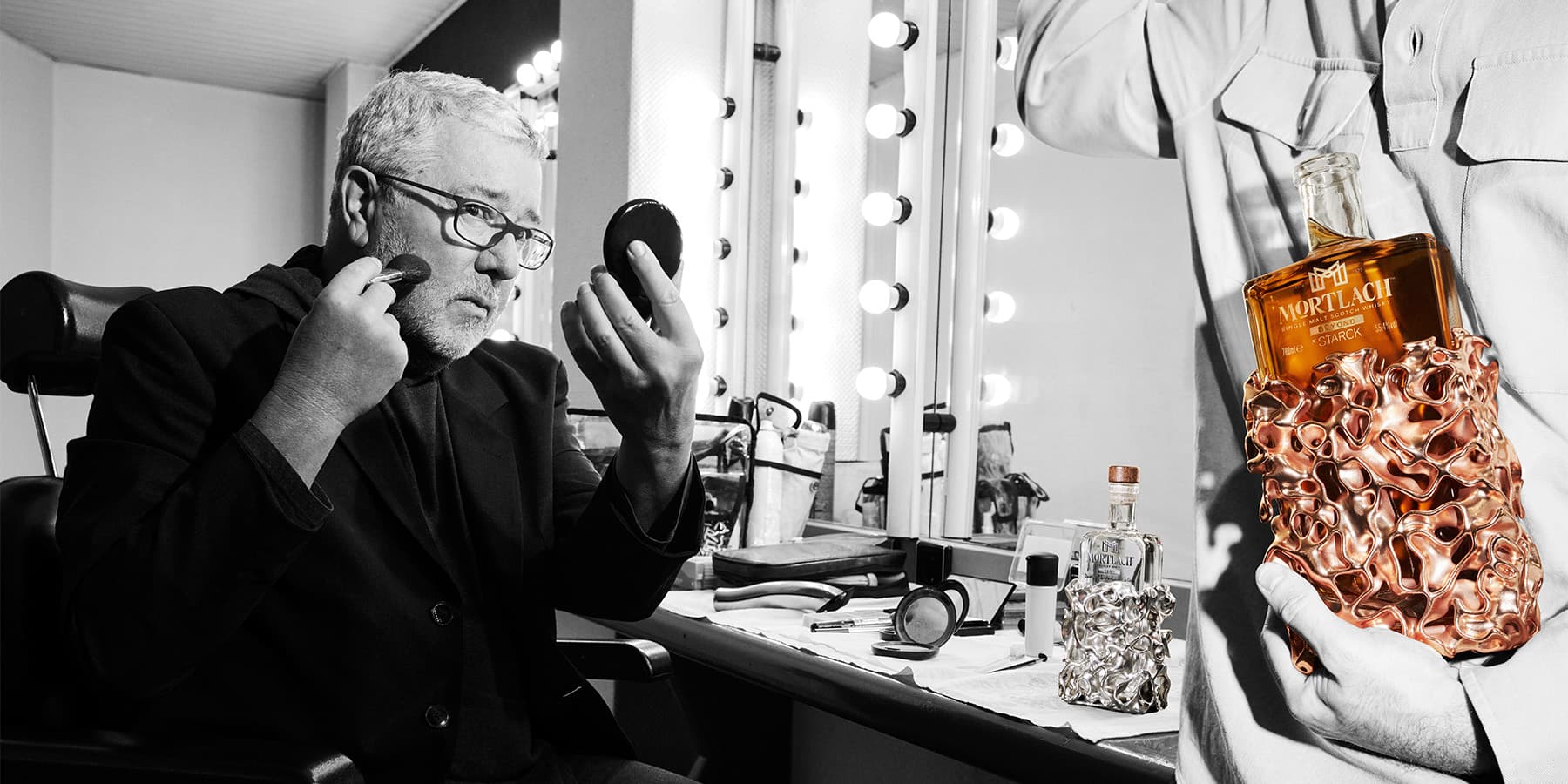 Philippe Starck putting on make up in black and white and a highlighted bottle of Mortlach x Starck L’Evolution Collection become 