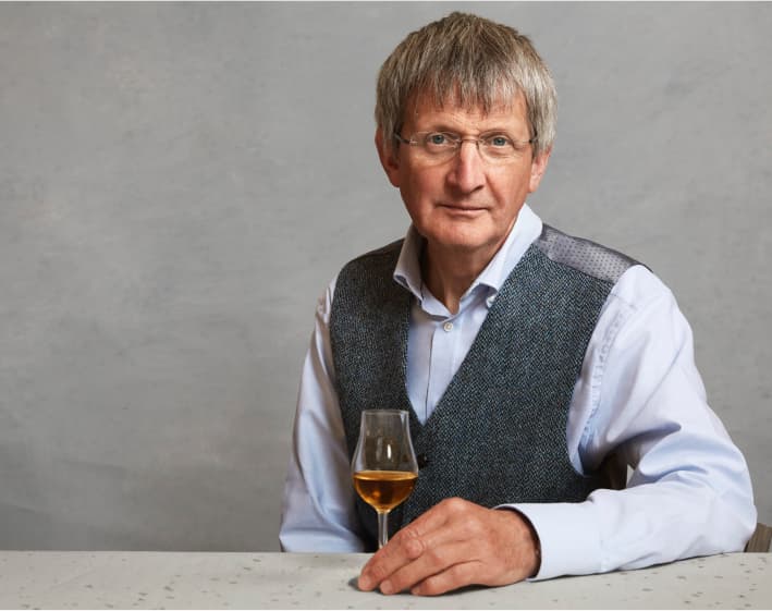 Dr Jim Beveridge OBE holding a dram of whisky