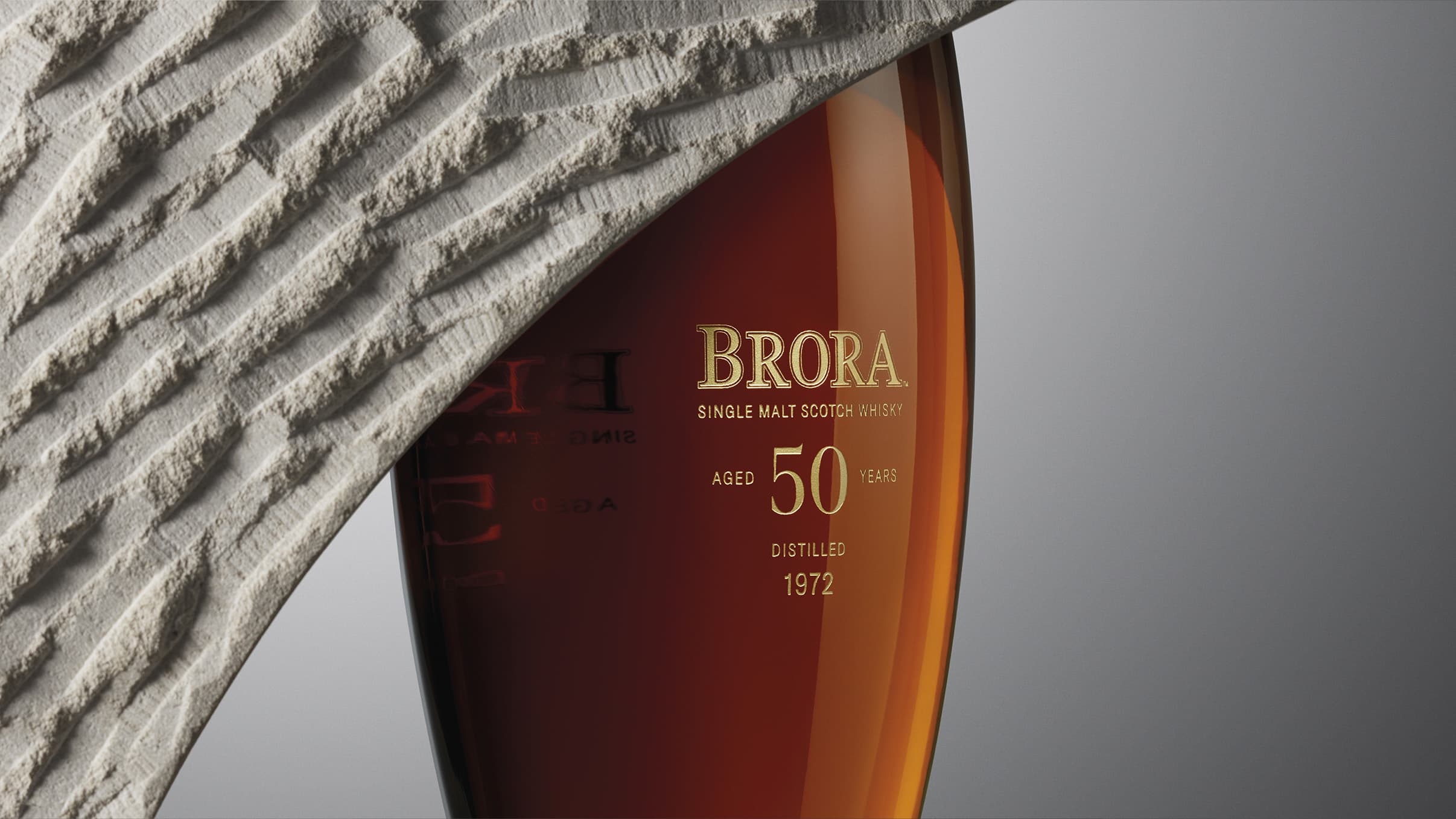 Close up of the Brora 50 Year old decanter and limestone sculpture