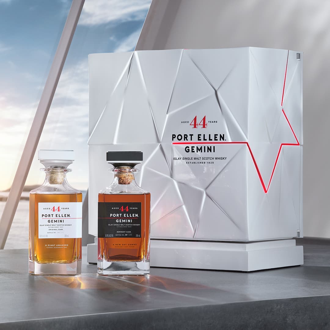 twin port ellen gemini whisky bottles in front of a white case and window with ocean view