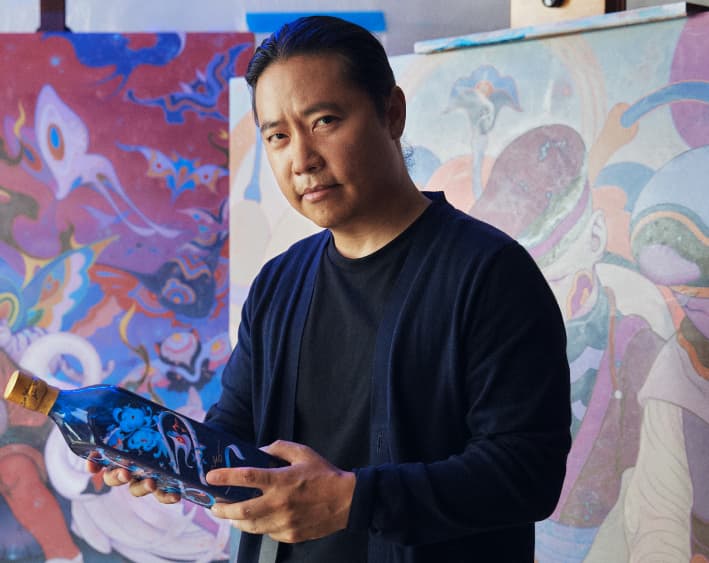 James Jean holding a bottle of Johnnie Walker Blue Lunar New Year 2024 in his studio
