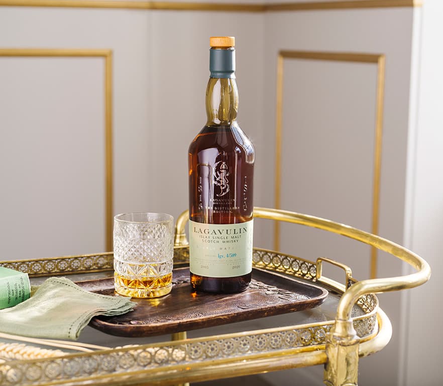 Lagavulin 2020 bottle and neat serve on top of a drinks trolley